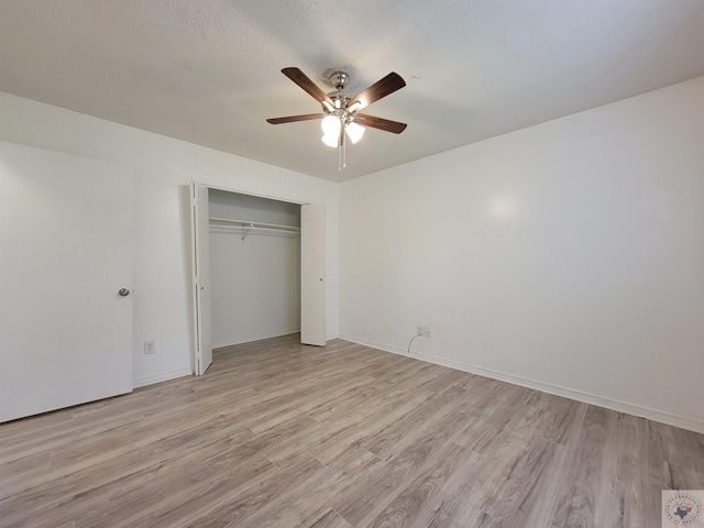 unfurnished bedroom featuring a textured ceiling, light hardwood / wood-style flooring, a closet, and ceiling fan