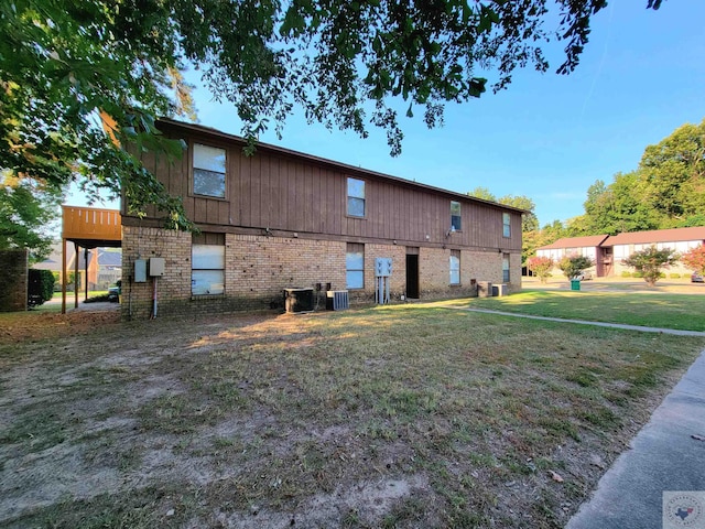 rear view of property with a yard and cooling unit