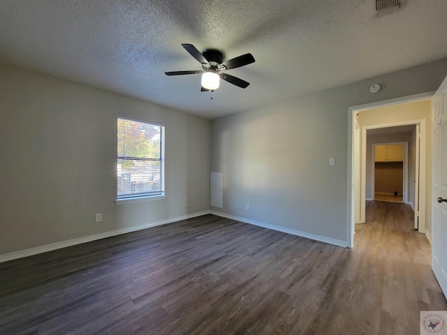 empty room featuring dark wood-type flooring, a textured ceiling, and ceiling fan