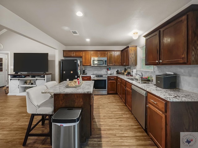 kitchen featuring stainless steel appliances, light wood-type flooring, visible vents, and tasteful backsplash