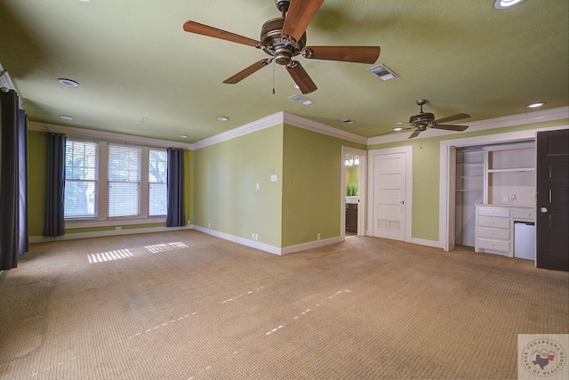 unfurnished living room featuring ornamental molding, light colored carpet, visible vents, and baseboards