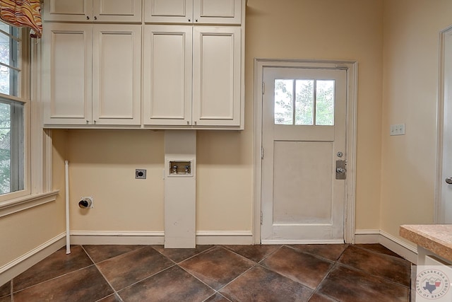 washroom featuring dark tile patterned flooring, washer hookup, baseboards, cabinet space, and electric dryer hookup