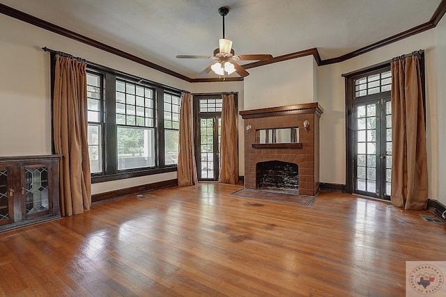 unfurnished living room featuring crown molding, light wood-style flooring, a fireplace with flush hearth, ceiling fan, and baseboards