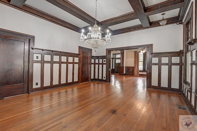 interior space featuring beam ceiling, visible vents, ornamental molding, wood finished floors, and coffered ceiling