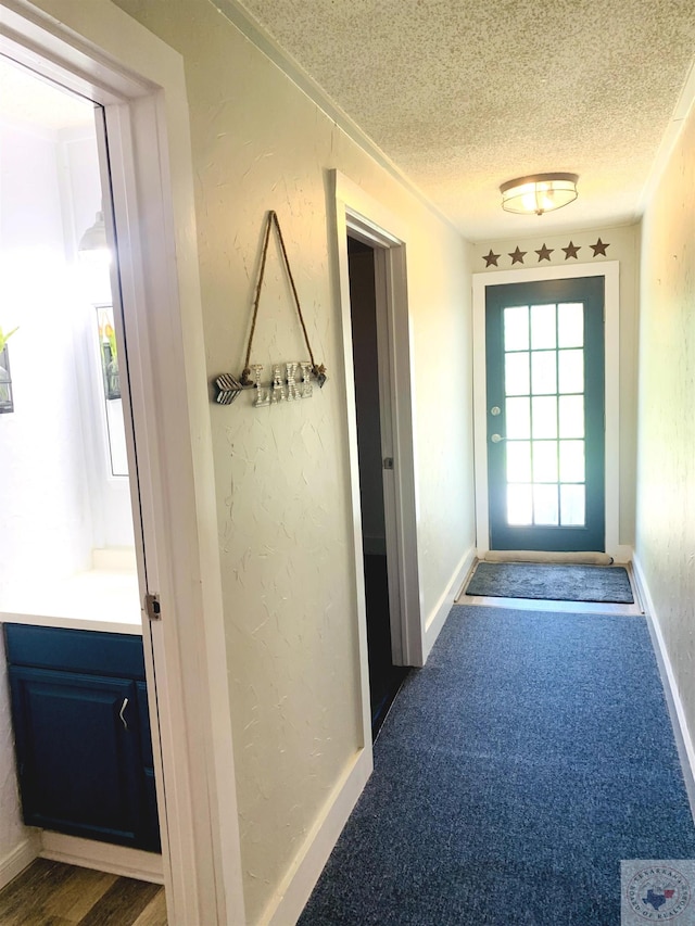 doorway featuring dark wood-type flooring and a textured ceiling