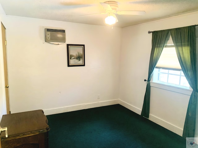 spare room featuring ceiling fan, dark carpet, and a wall unit AC