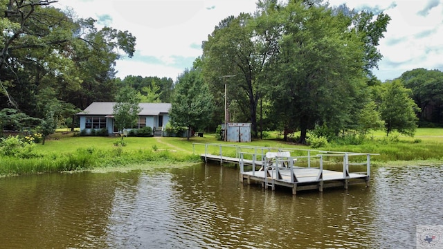 view of dock featuring a water view and a yard