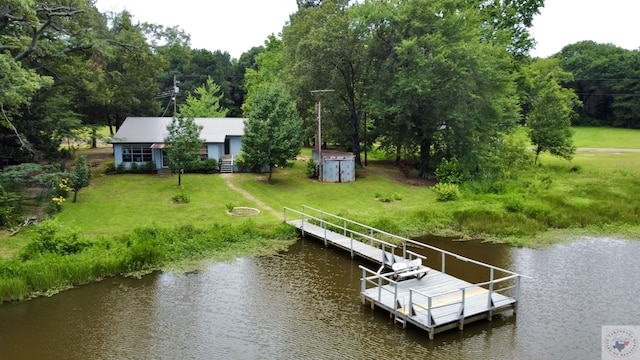 view of dock featuring a lawn and a water view