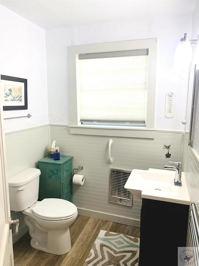 bathroom with hardwood / wood-style flooring, toilet, and vanity