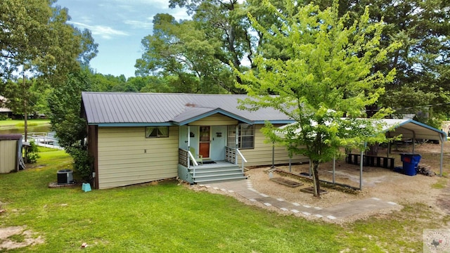 view of front of property with cooling unit, a front yard, and a carport