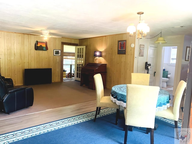 dining room with ceiling fan with notable chandelier and plenty of natural light