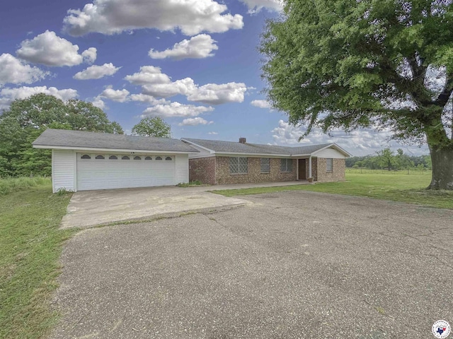 ranch-style home with an attached garage, driveway, and a front yard