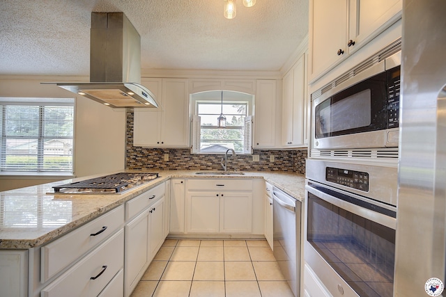 228 E Greenfield Dr, Wake Village, TX 75501 - kitchen featuring island exhaust hood, appliances with stainless steel finishes, a sink, a textured ceiling, and light tile patterned flooring