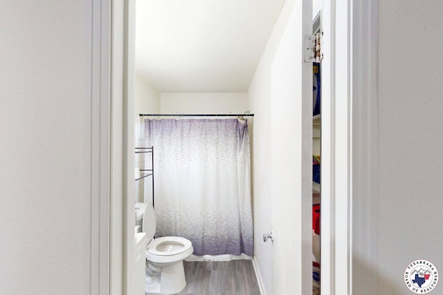1205 W 40th St, Texarkana, TX 75501 - full bath with wood finished floors, toilet, a shower with curtain, and baseboards