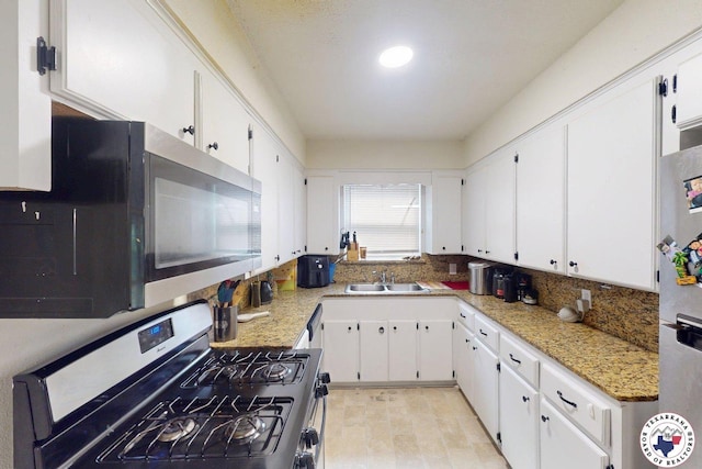 1205 W 40th St, Texarkana, TX 75501 - kitchen with stainless steel appliances, a sink, and white cabinetry