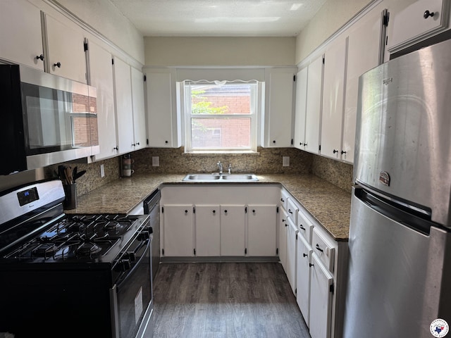 1205 W 40th St, Texarkana, TX 75503 - kitchen with stainless steel appliances, wood finished floors, white cabinets, and backsplash