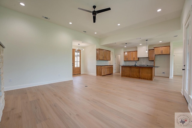 unfurnished living room featuring ceiling fan and light wood-type flooring