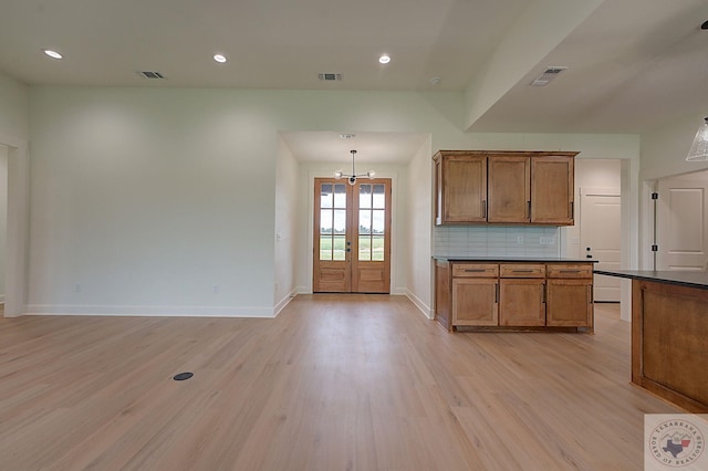 kitchen featuring light wood-type flooring, french doors, pendant lighting, and tasteful backsplash