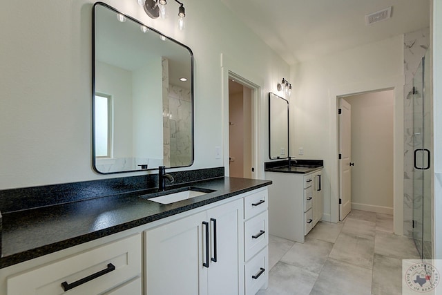 bathroom with a shower with door and vanity