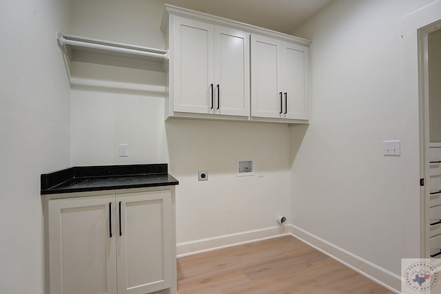 laundry room with hookup for a washing machine, light hardwood / wood-style flooring, hookup for an electric dryer, and cabinets