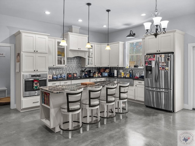 kitchen with white cabinetry, pendant lighting, appliances with stainless steel finishes, and a center island