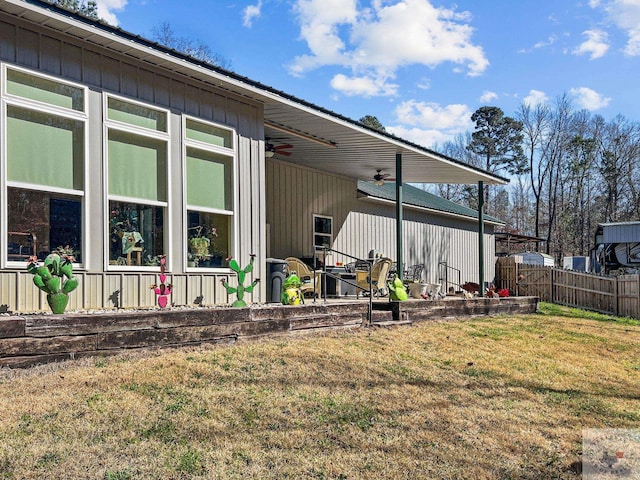 view of home's exterior with a lawn and ceiling fan