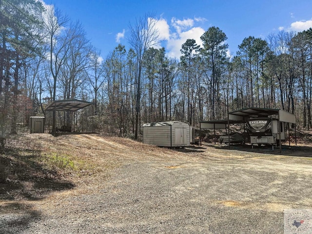 view of yard featuring a storage shed and a carport