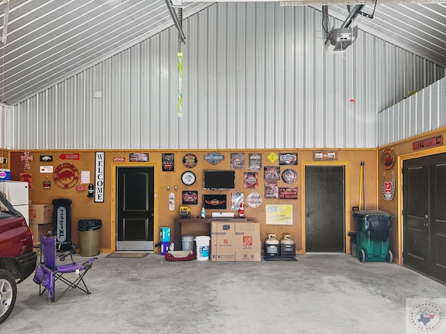 garage featuring wooden walls and a garage door opener