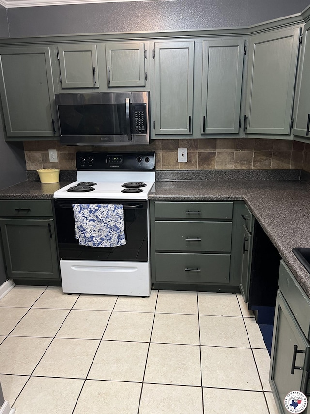 3609 Belmont Ave, Texarkana, AR 71854 - kitchen with electric range, stainless steel microwave, light tile patterned flooring, and dark countertops