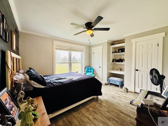 bedroom with wood finished floors, ornamental molding, and a ceiling fan