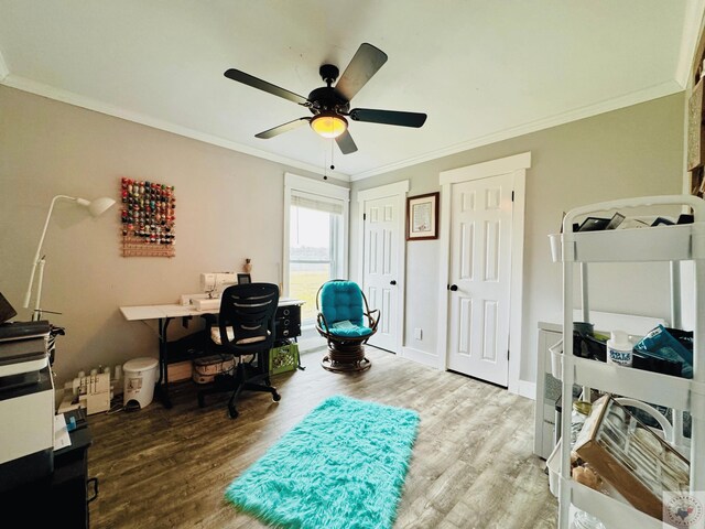 office featuring a ceiling fan, crown molding, baseboards, and wood finished floors