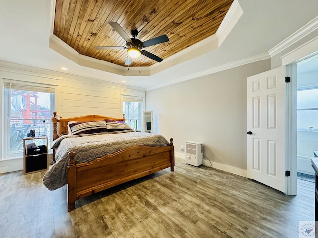 bedroom featuring wood finished floors, baseboards, a tray ceiling, ornamental molding, and wooden ceiling