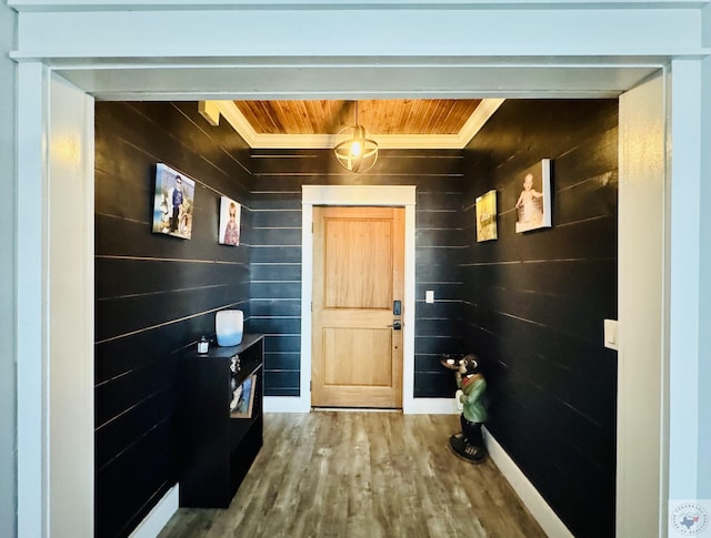 interior space with baseboards, wood ceiling, and wood finished floors