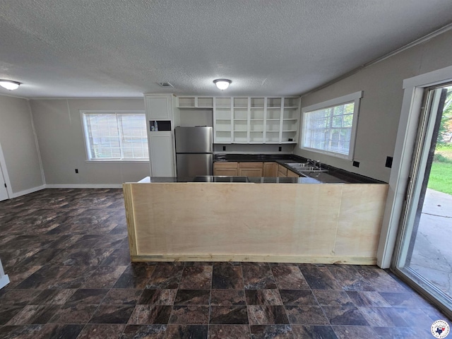 1405 S Fulton St, Hope, AR 71801 - kitchen featuring freestanding refrigerator, open shelves, a sink, dark countertops, and stone finish flooring