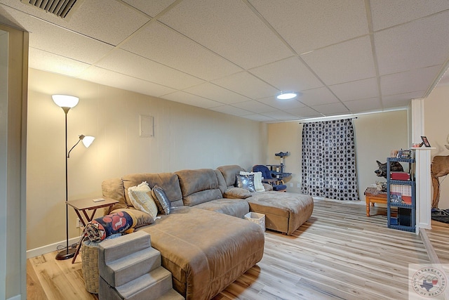 living room with light wood-type flooring and a paneled ceiling