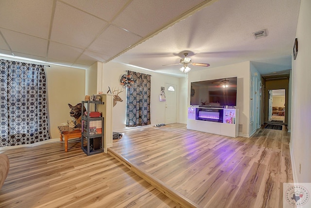 living room featuring ceiling fan, hardwood / wood-style floors, and a paneled ceiling