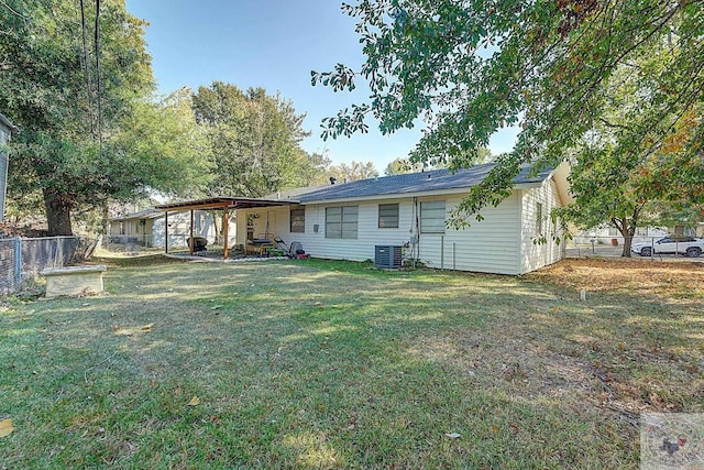 back of property featuring a lawn and central air condition unit