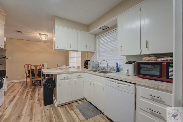 kitchen with white cabinets, light hardwood / wood-style floors, sink, kitchen peninsula, and white dishwasher