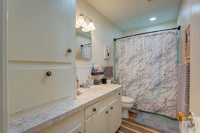 bathroom featuring hardwood / wood-style flooring, toilet, a shower with shower curtain, and vanity