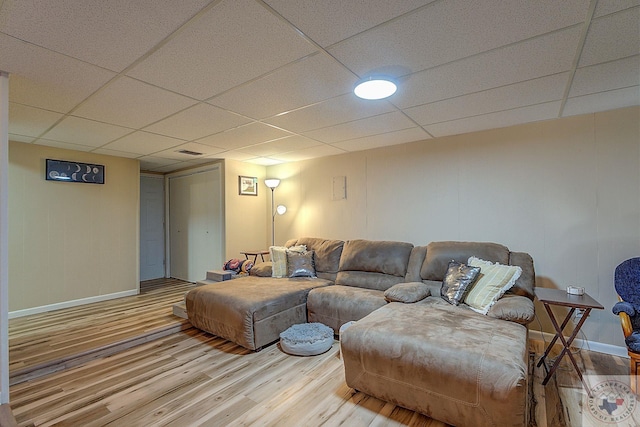 living room with hardwood / wood-style flooring and a paneled ceiling