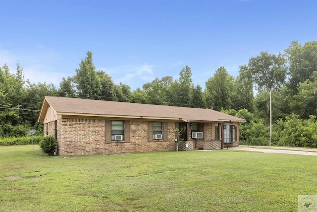 ranch-style home with cooling unit and a front lawn