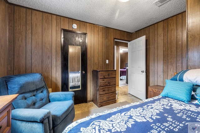 bedroom featuring wood walls and a textured ceiling