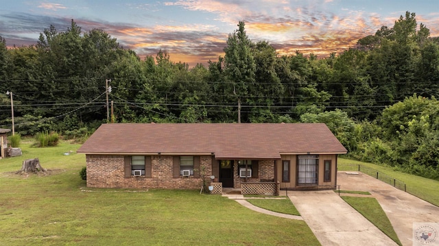 view of front of house featuring covered porch, cooling unit, and a yard