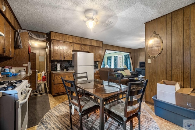 dining room with wood walls and a textured ceiling