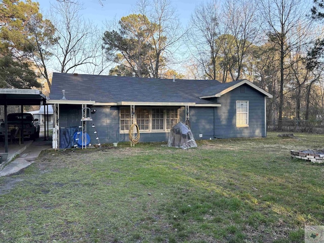 view of front of property with an attached carport, roof with shingles, and a front lawn