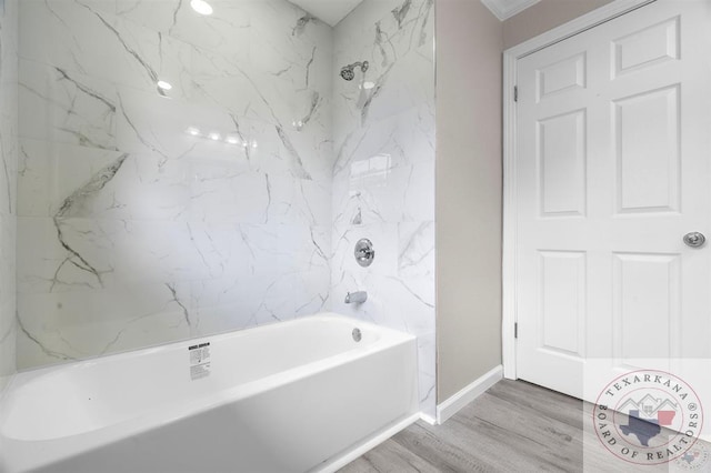 bathroom with hardwood / wood-style flooring and tiled shower / bath