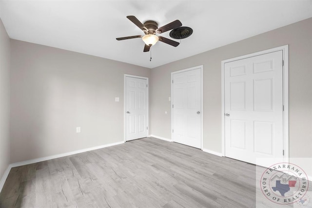 unfurnished bedroom featuring ceiling fan, two closets, and light hardwood / wood-style floors