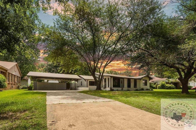 view of front of home with a carport and a yard