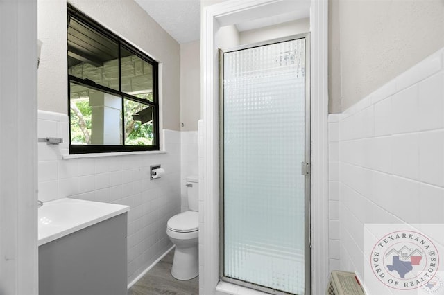 bathroom featuring vanity, toilet, tile walls, and hardwood / wood-style floors