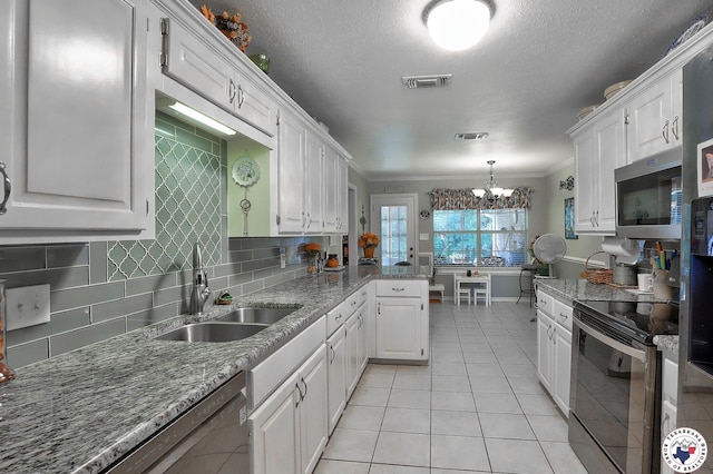 203 Peter Alan St, Wake Village, TX 75501 - kitchen featuring stainless steel appliances, white cabinetry, a chandelier, ornamental molding, and backsplash